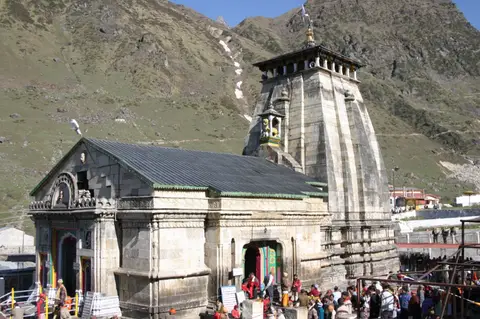 Kedarnath temple below the snow peaks of the Garhwal Himalaya, pilgrims at the steps